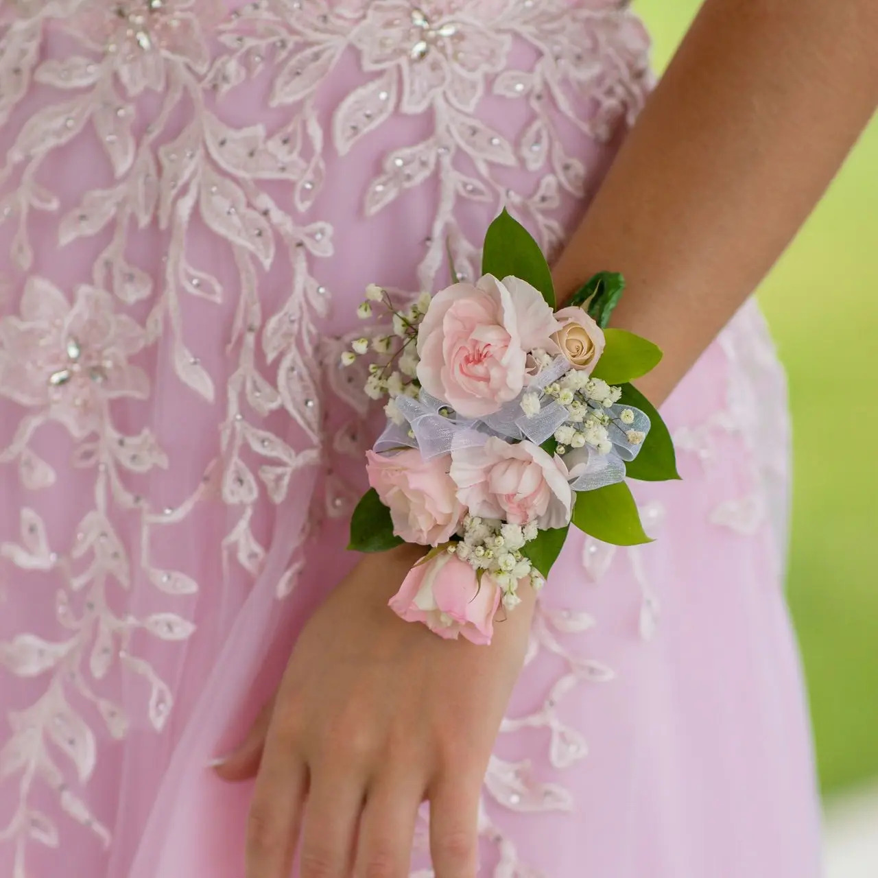 woman in pink floral dress holding white flower bouquet